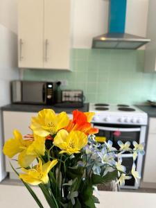 un jarrón de flores sentado en un mostrador en una cocina en Shakespeare House 6 bedroom 10 beds stay up to 14 people, en Derby