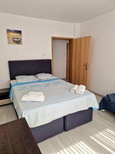 a bedroom with a bed with two towels on it at Апартамент Бижу М in Pomorie +2 photos