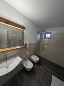 a bathroom with a sink and a toilet and a shower at Hotel Eden Guesthouse in Marlengo
