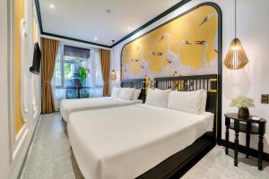 Postel nebo postele na pokoji v ubytování Rokas Hoi An Boutique Hotel