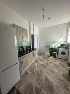Una cocina con un refrigerador blanco y una estufa. en Shakespeare House 5 bedroom 7 beds stay up to 12 people, en Derby