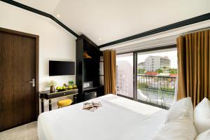 Postel nebo postele na pokoji v ubytování Rokas Hoi An Boutique Hotel