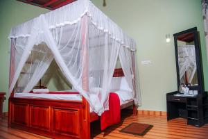 a bed with a canopy in a room at Freedom Guest Inn Ella in Ella