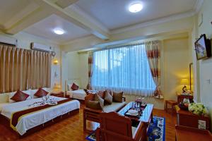 pokój hotelowy z 2 łóżkami, kanapą i stołem w obiekcie 79 Living Hotel w mieście Mandalaj