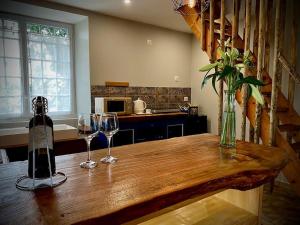 a table with two wine glasses and a bottle at Gîte Duplex Vallée de la Vienne in Availles-Limouzine