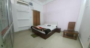 a small bedroom with a bed and a chair at Chitrakoot palace in Ayodhya
