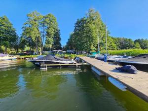 a group of boats docked at a dock in the water at Dom Letniskowy nad jeziorem in Wilkasy