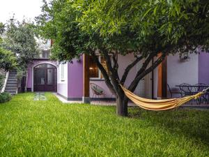 a hammock hanging from a tree in front of a house at Giardino Carya - Giarre Centro in Giarre