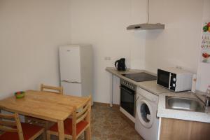 a kitchen with a table and a sink and a refrigerator at Zwei-Zimmer-Wohnung im Zentrum in Dortmund