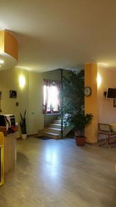 sala de estar con escalera y reloj en la pared en Cerruti Hotel, en Vercelli
