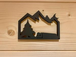 a cutout of a house with a man and trees at Appartement LE 351 in Les Gets