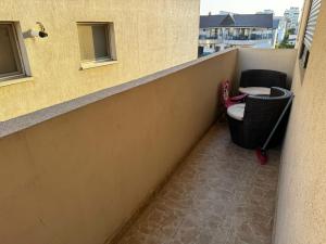 a balcony with a chair and a desk on a building at Bia's Apartament in Mamaia Nord