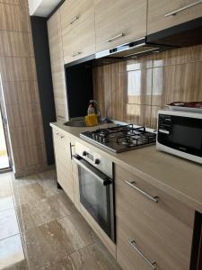 a kitchen with a stove and a microwave at Bia's Apartament in Mamaia Nord