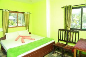a bedroom with a bed with a teddy bear on it at Dean Dale Cottages in Thekkady