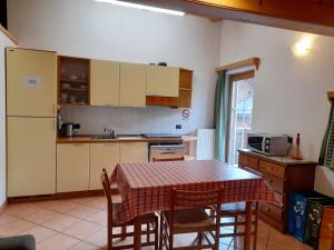 a kitchen with a table and chairs and a table and a microwave at Bait da Sant'Antoni in Livigno