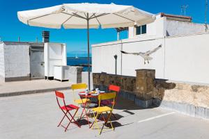 een vogel die over een tafel met stoelen en een parasol vliegt bij BluMarine by Vivimy in Gallipoli