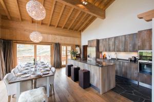 a kitchen and dining room with a table and chairs at Chalet Alexia in La Tzoumaz