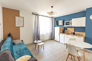 un soggiorno con un divano e un tavolo di L'Indigo "By Cottage d'Auch" ad Auch