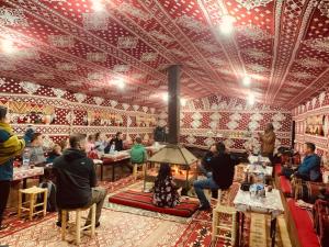 a group of people sitting at tables in a restaurant at Milk way desert in Wadi Rum