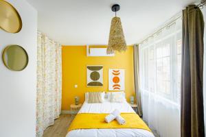 una camera da letto con un letto e una parete gialla di L'Indigo "By Cottage d'Auch" ad Auch Altre 8 foto