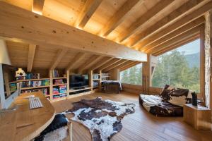 un soggiorno con una grande finestra e soffitti in legno di Chalet Alexia a La Tzoumaz