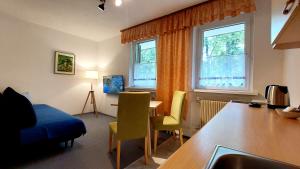 a living room with a table and two windows at Hiša ob jezeru - House by the Lake in Kranjska Gora