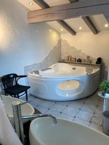 a bathroom with a tub and a table and a chair at Duplex Ferienwohnung Edelweiss in Grächen