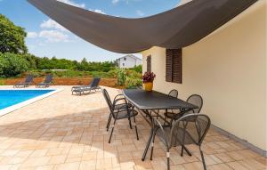 a patio with a table and chairs next to a pool at 3 Bedroom Amazing Home In Sukosan in Sukošan +24 photos