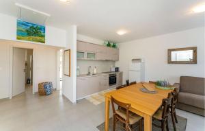 a kitchen and dining room with a wooden table in a room at 3 Bedroom Amazing Home In Sukosan in Sukošan