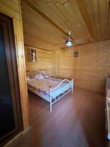a bedroom with a bed in a wooden room at Pensiunea Delia in Vadu