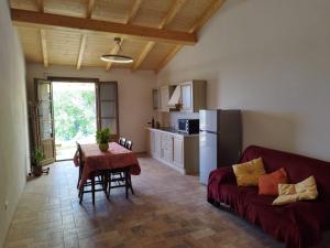 un soggiorno con un divano rosso e un tavolo di Agriturismo Eco-Pescaia a Montepulciano a Montepulciano