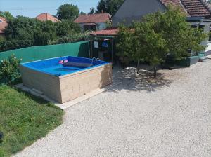 a hot tub in a yard next to a house at Kolon Vendégház in Zalavár