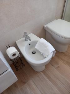 ein weißes Badezimmer mit Toilette und Waschbecken in der Unterkunft Villa Spiaggia degli Angeli in Porto Cesareo + 35 Fotos