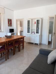 ein Wohnzimmer mit einem Holztisch und einer Couch in der Unterkunft Villa Spiaggia degli Angeli in Porto Cesareo