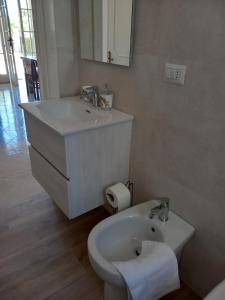 ein weißes Badezimmer mit Waschbecken und Toilette in der Unterkunft Villa Spiaggia degli Angeli in Porto Cesareo