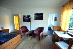 a bedroom with a bed and two chairs and a table at Ferienwohnung Am Rathaus in Garmisch-Partenkirchen