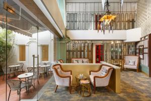 a lobby of a library with chairs and tables at Hotel Ambassador by ACE Hotels, Kathmandu in Kathmandu