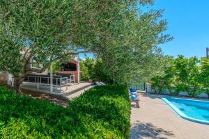 a yard with a swimming pool and a tree and a house at HOLIDAY HOUSE LAVANDA in Gornji Zemunik