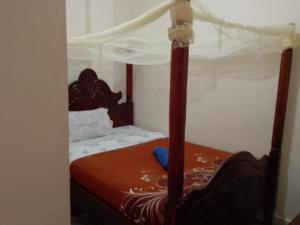 a bedroom with a bed with a canopy at Wana Guest House in Rubirizi