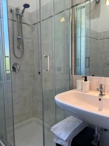 a bathroom with a sink and a shower at La Flacca Rooms in Sperlonga