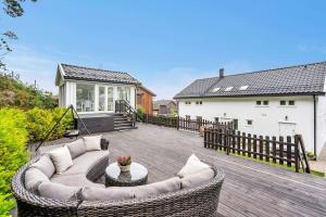 eine Terrasse mit einem Sofa auf einer Holzterrasse in der Unterkunft Zapraszamy w nasza słoneczna Przestrzeń in Søgne + 16 Fotos