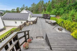 einen Hinterhof mit einer Holzterrasse und einem Haus in der Unterkunft Zapraszamy w nasza słoneczna Przestrzeń in Søgne