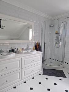 ein weißes Badezimmer mit zwei Waschbecken und einer Dusche in der Unterkunft Zapraszamy w nasza słoneczna Przestrzeń in Søgne