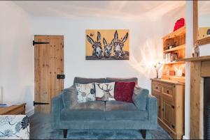 a living room with a couch and a painting on the wall at Brook Cottage in Temple Ewell
