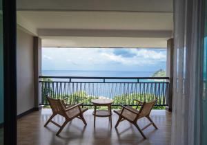 a balcony with a table and chairs and a view of the ocean at Dusit Buncha Koh Tao by Riya Group in Ko Tao