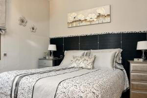 a bedroom with a large bed with a black headboard at Las Glicinias del Jerte in Casas del Castañar