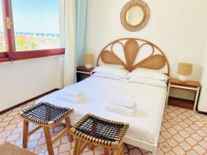 a bedroom with a bed with two chairs and a mirror at Casa Rea in Francavilla al Mare