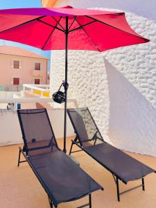 a red umbrella and two chairs on a roof at Casa Rea in Francavilla al Mare