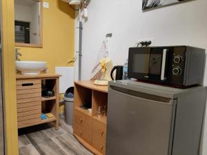 a microwave on top of a refrigerator in a kitchen at Chambre d hotes le pigeonnier in Fromelles