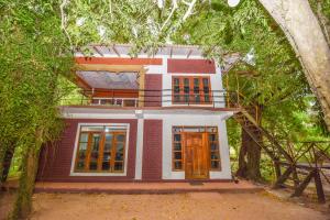 a house framed by trees with an archway at Elephant Trio Sigiriya in Sigiriya
